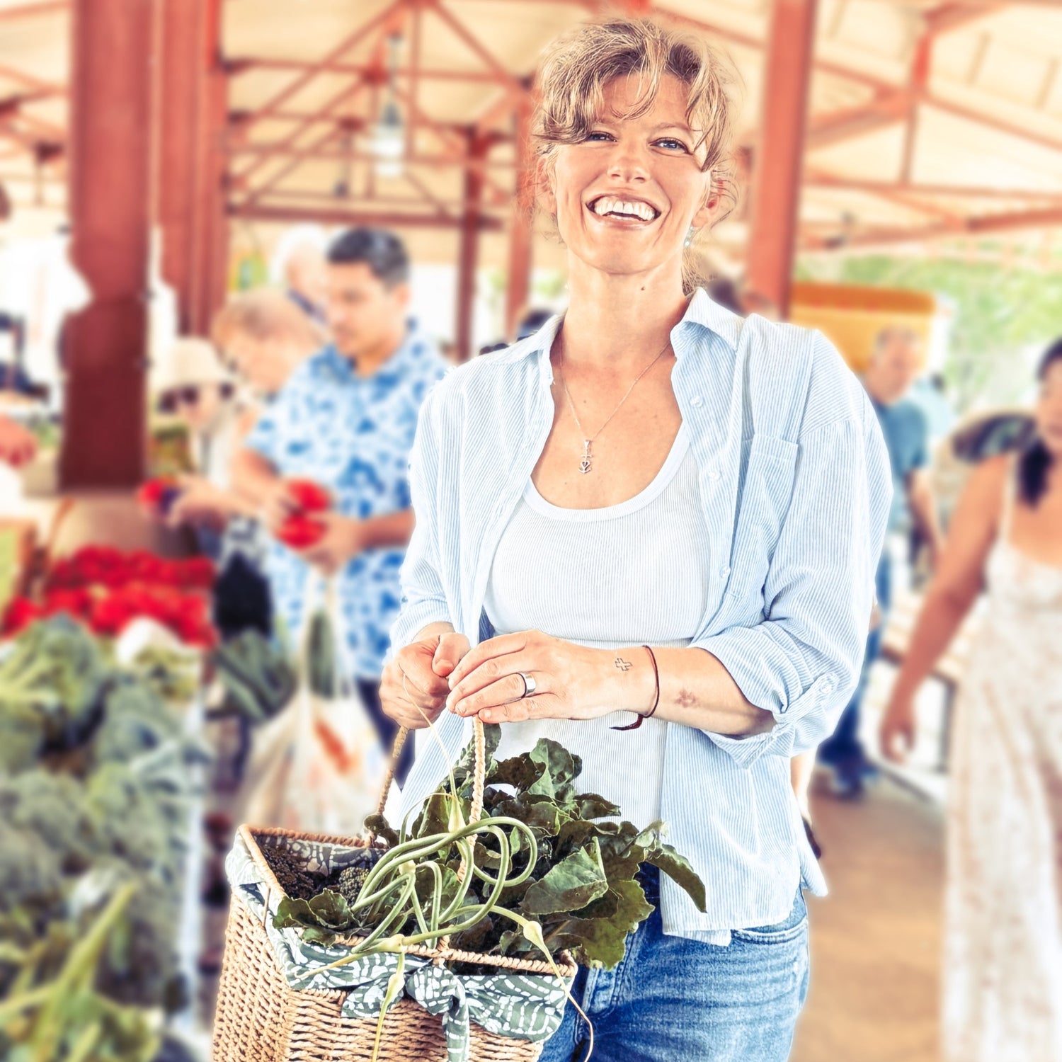 Woman holding a basket of fresh produce at an outdoor market.