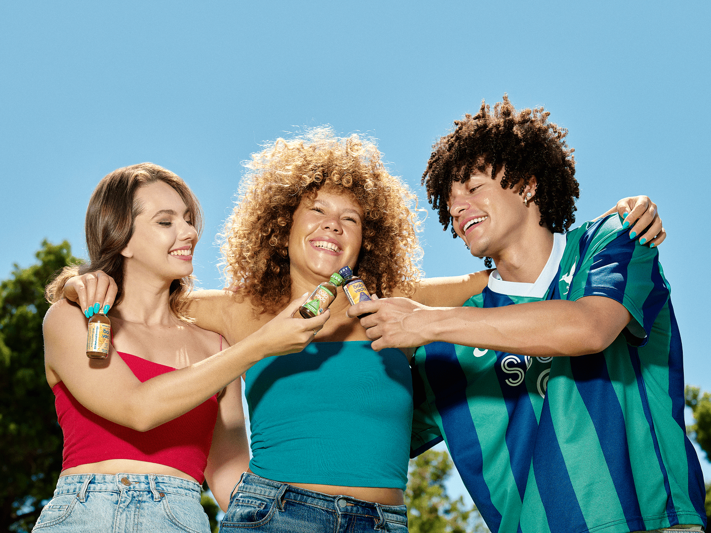 three people together and two people on outside cheering the balaveda Clean Energy Shots with blue background.