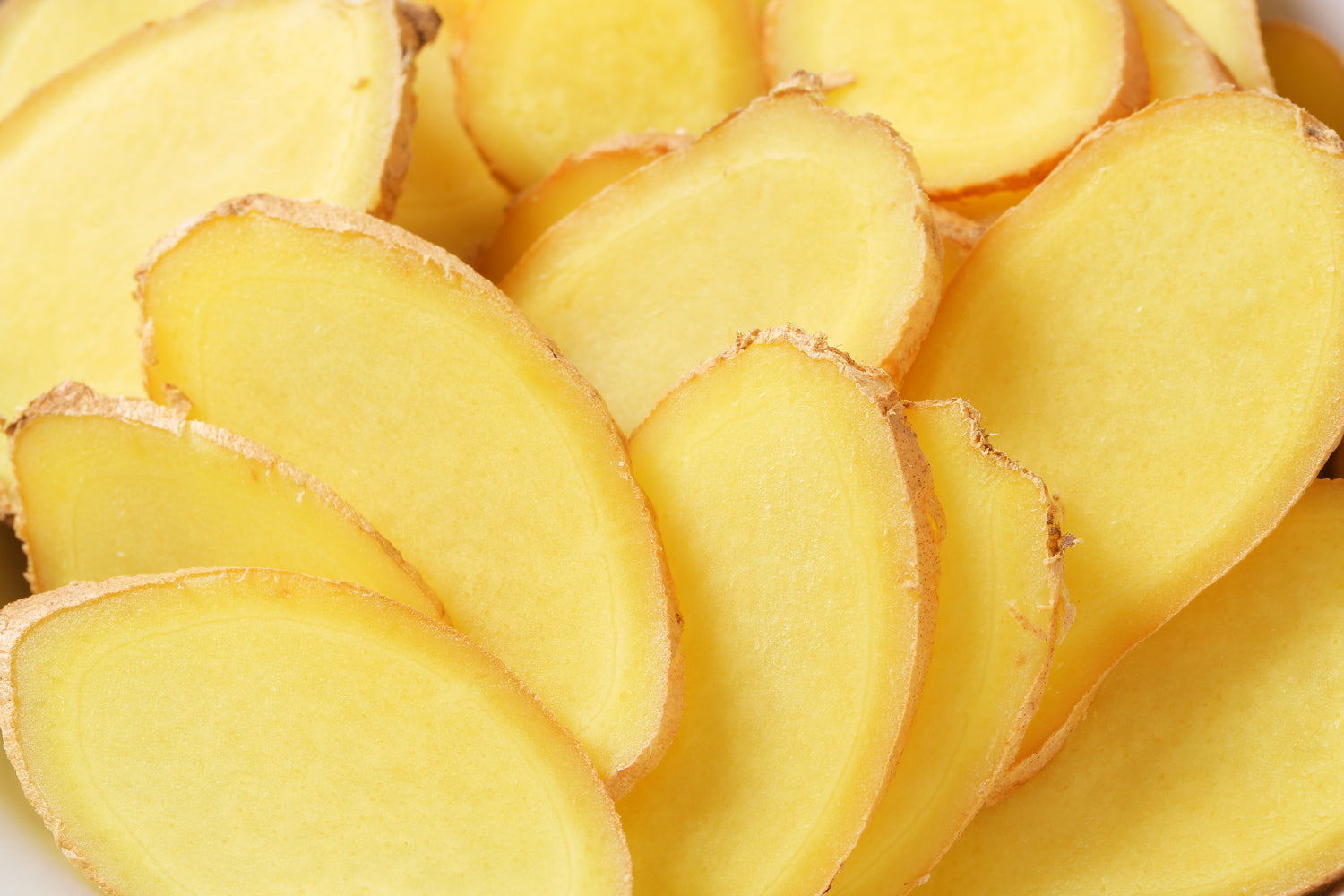 Close-up of sliced ginger pieces on a white background